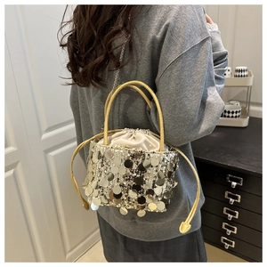 Dettaglio di borsa a secchiello con paillettes argento con manico giallo e coulisse