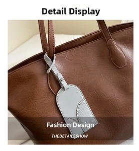 Detailed macro view showing the pebbled leather texture of a dark brown large tote bag