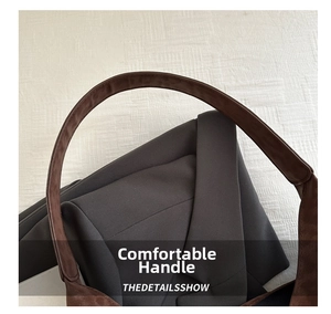 Detail of wide brown suede handle with reinforced stitching on a vintage leopard tote bag