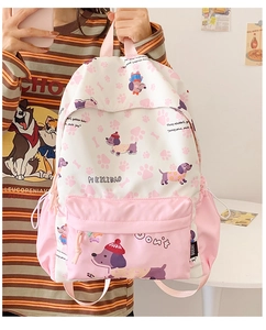 Close-up of pink and white cartoon backpack with dog patterns and front zipper pocket