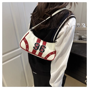 Detail view of white leather shoulder bag featuring red panels and number 96 embroidery