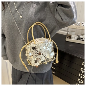 Detailed shot of sequin bucket bag with satin drawstring inner and metal chain strap