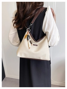 Détail du sac seau en toile avec bordure en cuir marron et breloque en perles de bois