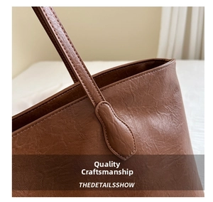 Macro shot of durable stitching and handle connection on brown litchi pattern tote bag
