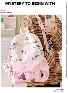 Detail of pink and white cartoon backpack with dachshund print and plush doll pendant