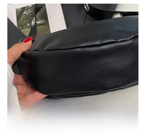 Close-up of precise stitching and premium leather texture on a black underarm bag