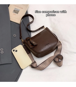 Deep brown leather bucket bag shown with a phone for size comparison and scale