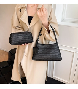 Close-up of black woven leather shoulder bag with matching rectangular clutch set