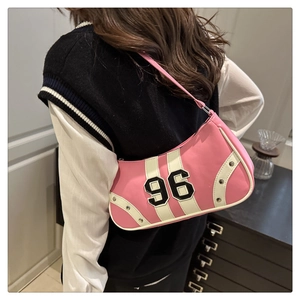 Detail of pink retro underarm bag with number 96 patch and metallic studs on strap