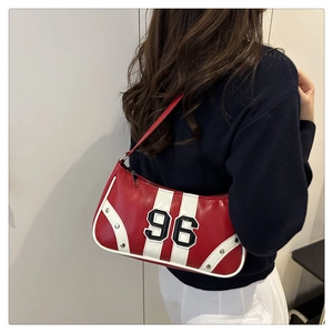 Detail of red leather underarm bag featuring number 96 print and silver metal rivets