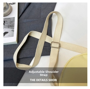 Detail of adjustable cream strap with silver metal buckle on a yellow canvas bag
