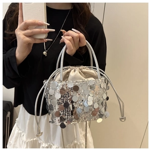 Close-up of silver sequin bucket bag featuring drawstring closure and chain strap