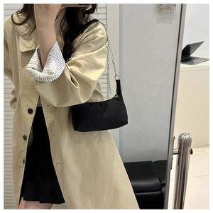 Mirror selfie showing a black nylon shoulder bag with silver chain on a trench coat