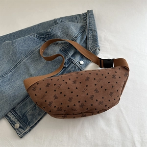 Brown corduroy waist bag with heart bow print and adjustable strap on denim background
