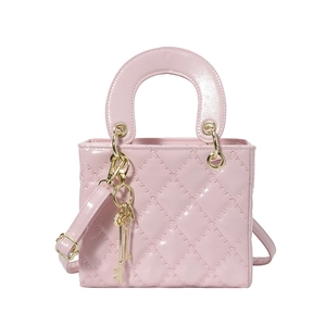 Borsa trapuntata in vernice rosa con finiture dorate e un manico superiore tondo
