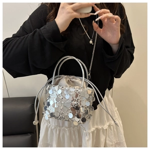 Macro detail of silver sequin handbag featuring drawstring lining and metal chain