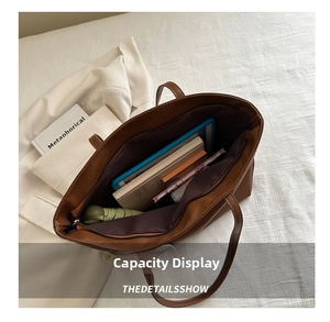 Macro view of spacious brown tote interior with tablet, books, and umbrella storage