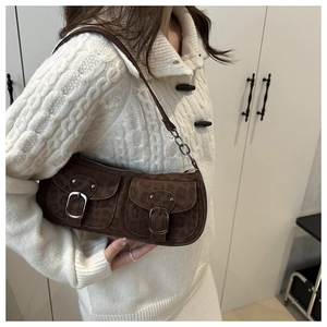 Détail du sac baguette en daim marron avec imprimé léopard discret et doubles poches avant