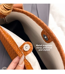 Detail of woven brown handbag showing the metal magnetic closure and interior structure