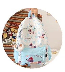 Detail of cartoon backpack featuring blue puppy prints and a plush dog charm pendant