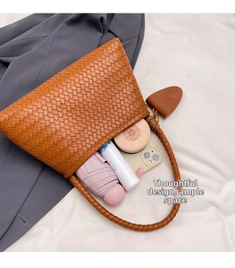 Spacious interior of woven shoulder bag showing umbrella, phone, and daily essentials