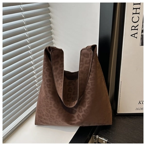 Macro detail of large brown leopard print tote bag with soft suede texture finish