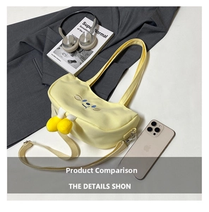 Detail of cute yellow canvas shoulder bag with cartoon embroidery and plush feet charms
