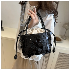Detail of black sequined bucket bag with drawstring satin lining and silver chain strap