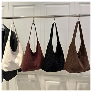 Macro shot of stylish leopard print suede tote bags in various colors on display
