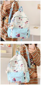 Detail of cute canvas backpack featuring cartoon dachshund prints and doll pendant