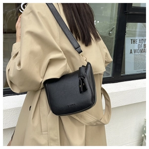 Detail of black vintage leather saddle bag with wide strap and fashion embossed lettering