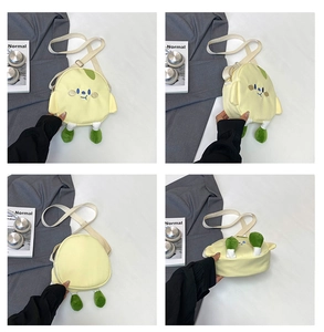 Close-up of yellow plush crossbody bag with cartoon embroidery and small green legs