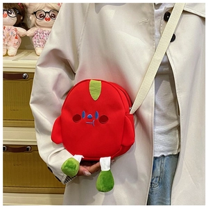 Detailed view of red cartoon plush crossbody bag with green legs and white woven strap