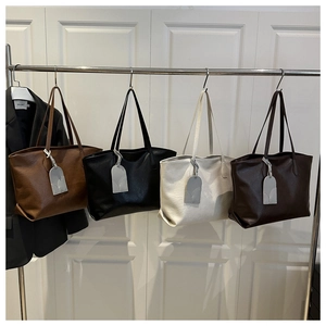 Detailed row of large tote bags in brown, black, white, and coffee soft textured leather