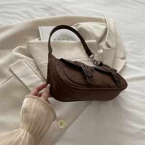 Vintage brown suede underarm bag with double flap pockets on minimalist blazer background
