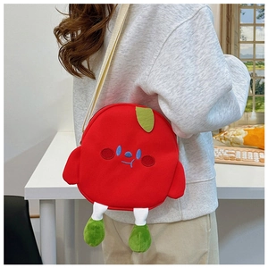 Detailed view of a red apple-shaped canvas crossbody bag with cute embroidered facial features