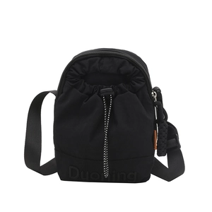 Black nylon drawstring crossbody bag with adjustable strap and embossed logo detail