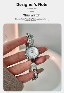 Gros plan d'un bracelet de montre argenté avec des pétales de camélia et des perles