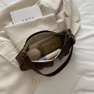 Deep brown suede baguette bag with leather buckle detail and spacious interior storage