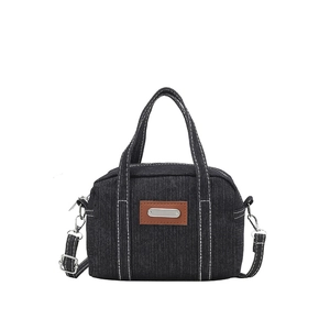 Navy blue denim crossbody bag with contrast white stitching and leather patch details