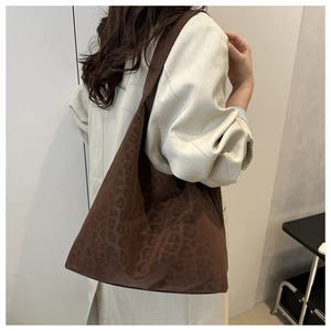 Detail of large leopard print tote bag showing soft suede texture and wide shoulder strap