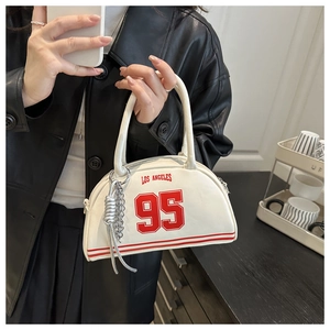 Detail of cream Boston bag featuring red Los Angeles print and silver chain accessory