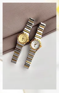 Detalle macro de dos relojes GEDI dorados con esfera de nácar sobre tela fina