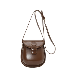 Sacoche marron foncé rétro avec finition polie et bandoulière réglable sur fond blanc