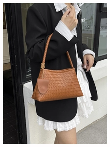 Detail of brown woven tote bag with matching coin purse shown in street style outfit