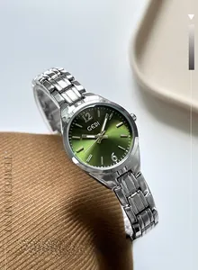 Detail of silver quartz watch with green sunray dial on brown textured fabric