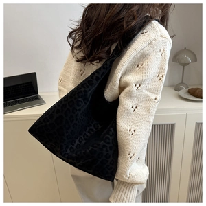 Detailed view of black leopard print hobo tote bag in soft velvet texture on shoulder