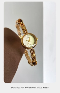 Detailed macro of gold watch with amber stone links designed for small wrists