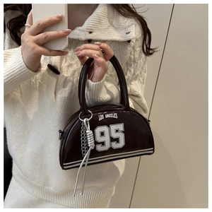 Detail of dark brown crescent bag with Los Angeles 95 print and silver tassel chain