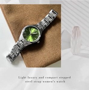 Detail of a luxury women's watch featuring a green sunray dial and silver steel band